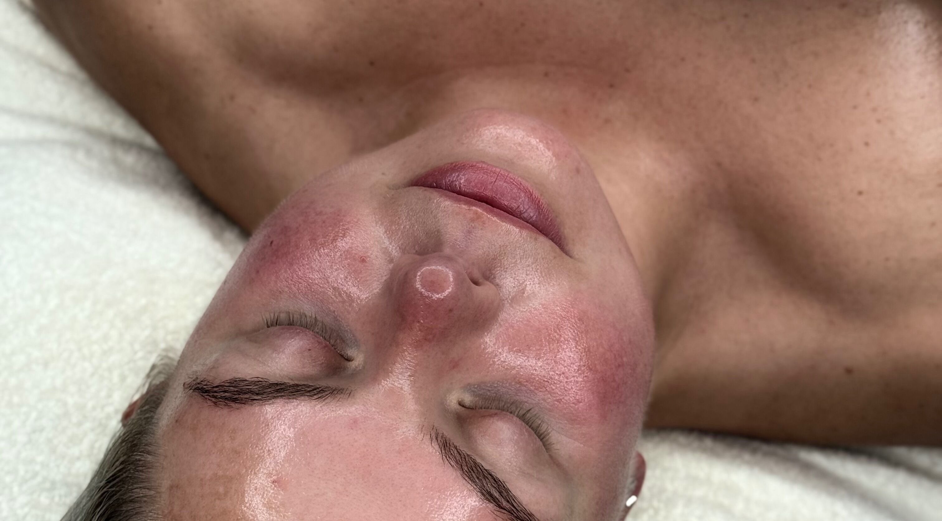 Relaxed client enjoying facial at The NUE Edit @ Fine Strokes, Chadderton, Oldham, England, GB.