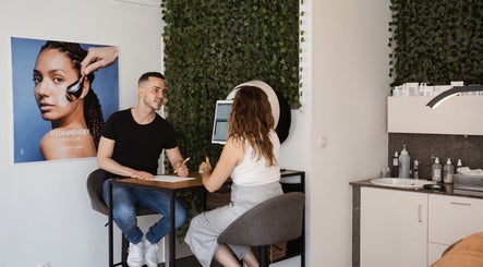 Professioneel consult bij The Skin Corner, Hasselt, Vlaams Gewest, BE met groene wand en huidverzorgingsproducten.