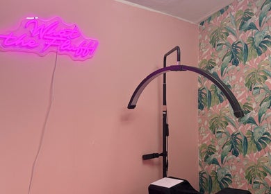 What the Fluff! Lashes & Brows cozy corner with pink neon and floral wall in Nottingham, England, GB.
