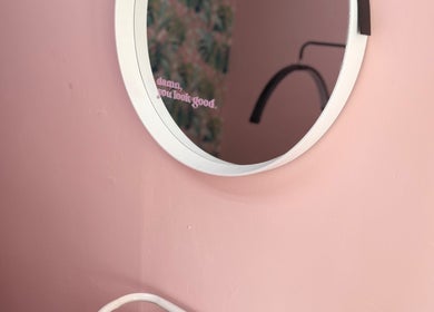 Elegant circular mirror on pink wall at What the Fluff! Lashes & Brows, Nottingham, England, GB.