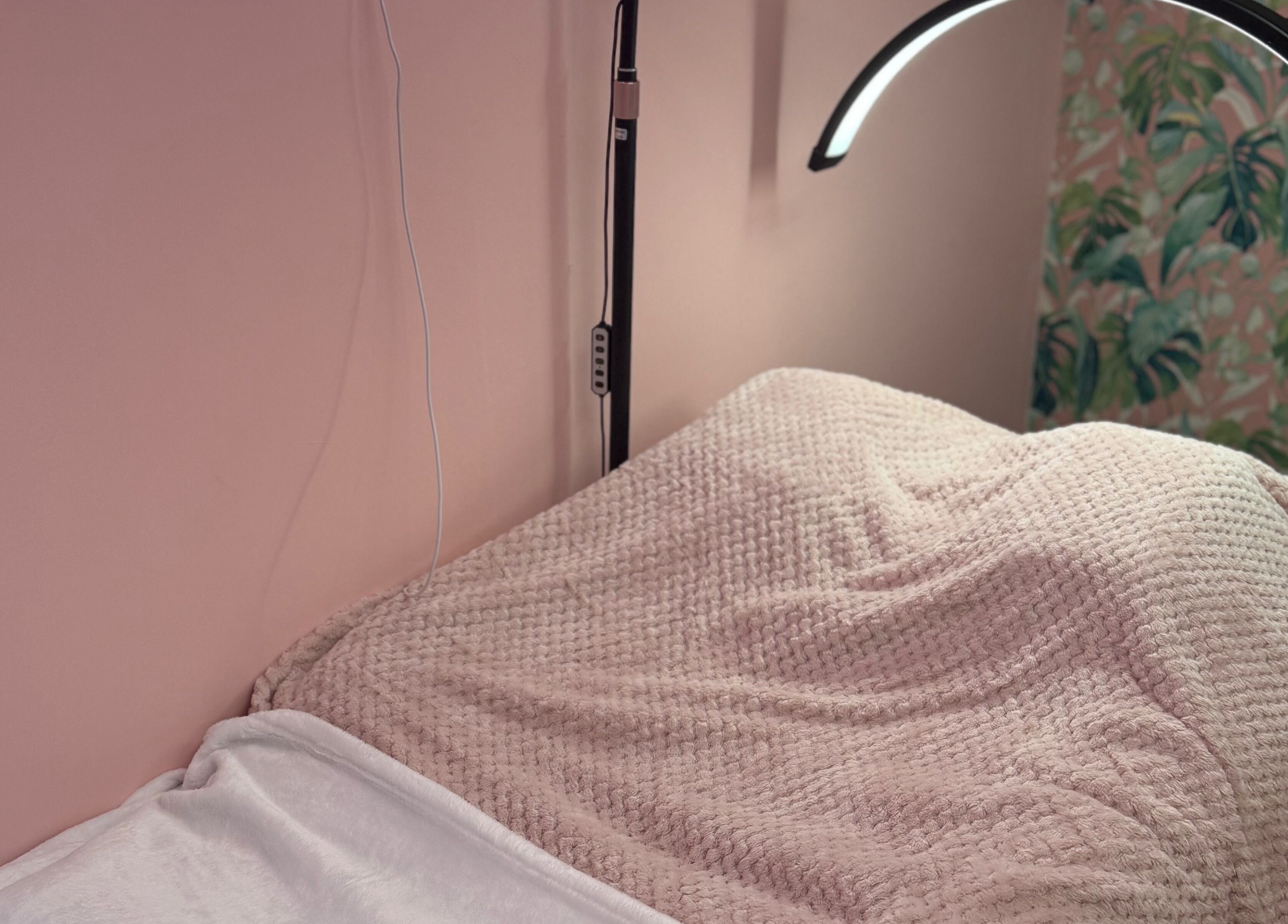 Comfortable treatment bed at What the Fluff! Lashes & Brows, Nottingham, England, GB with soft lighting.