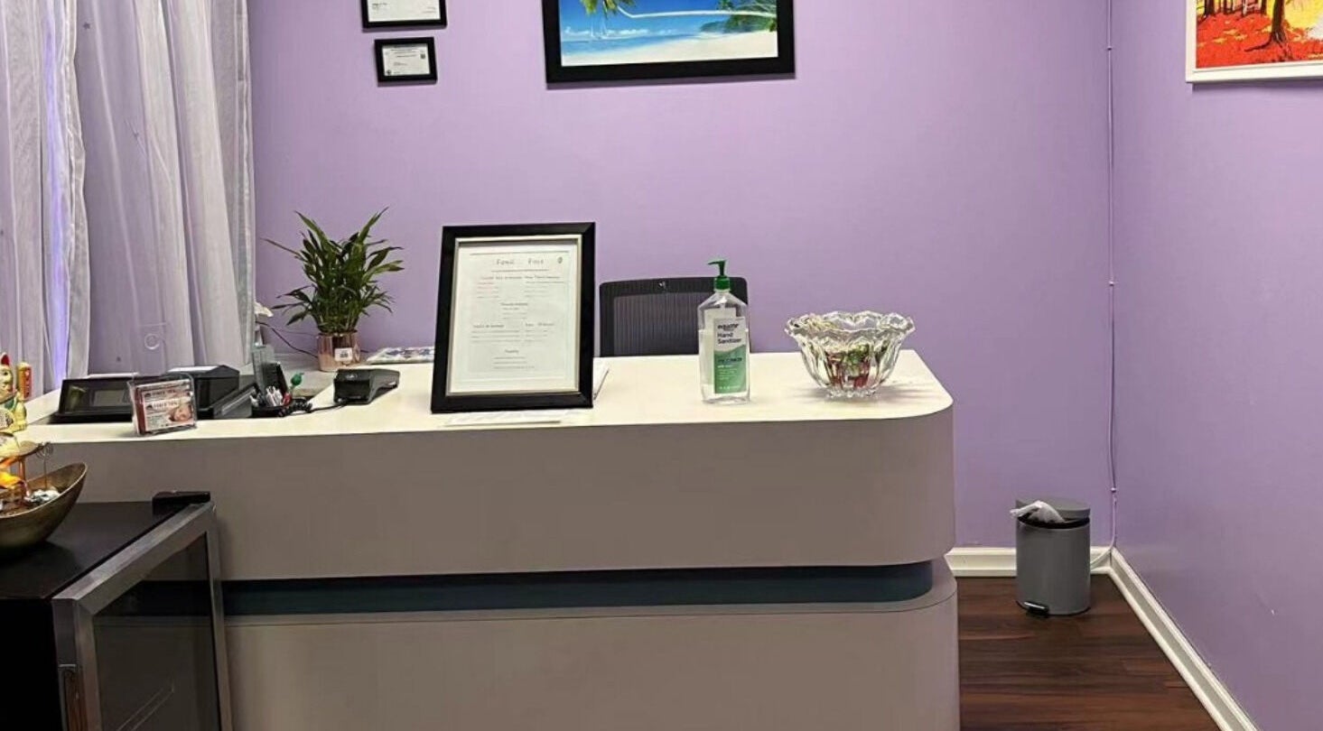 Reception desk at AA Foot & Body Spa in Lisle, Illinois, US with purple walls and decor.