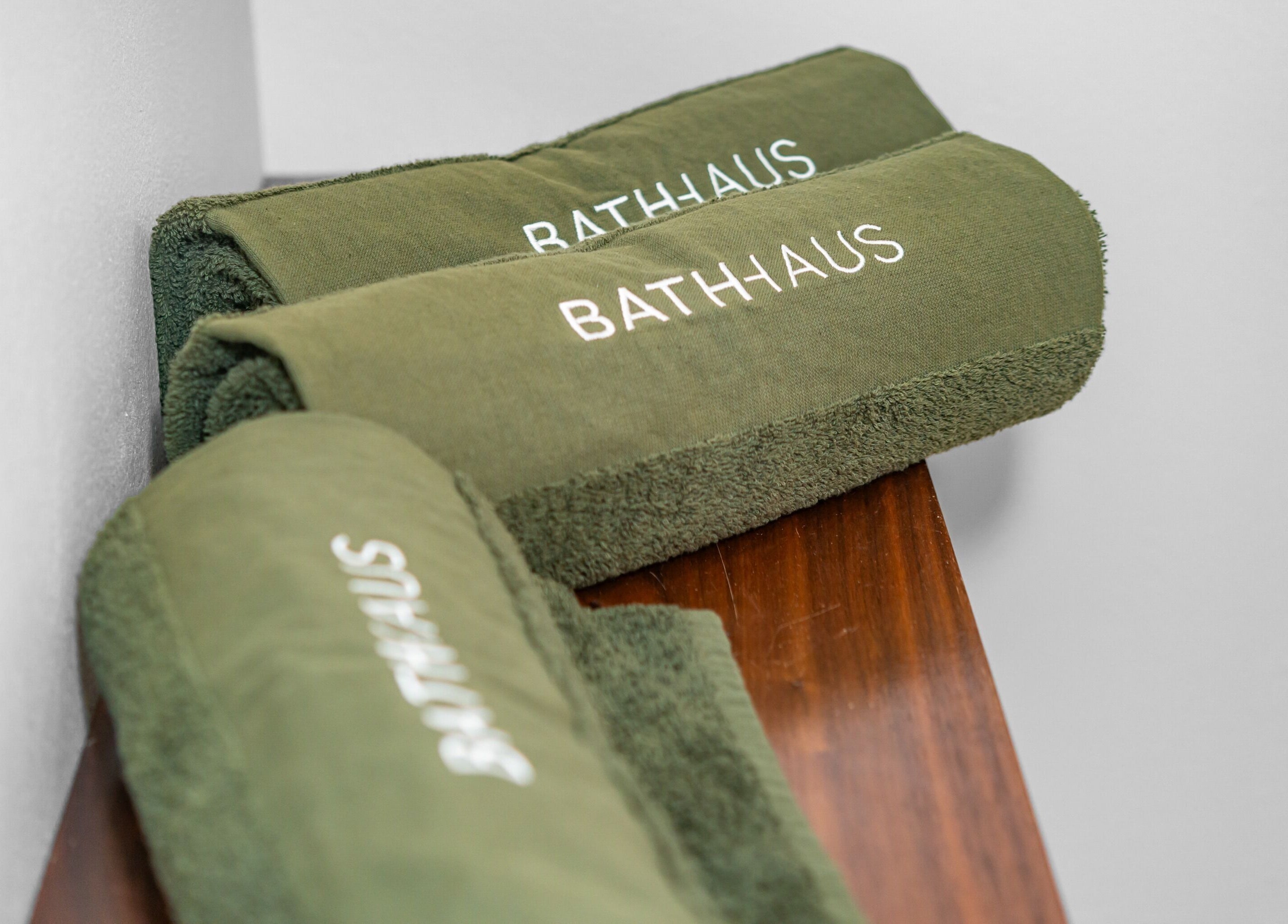 Elegant green towels branded Bath Haus Cronulla at wellness spa, Cronulla, New South Wales, AU.