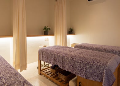 Relaxing massage room at Muscle Works, Bali, Bali, ID, featuring two massage tables with elegant decor.