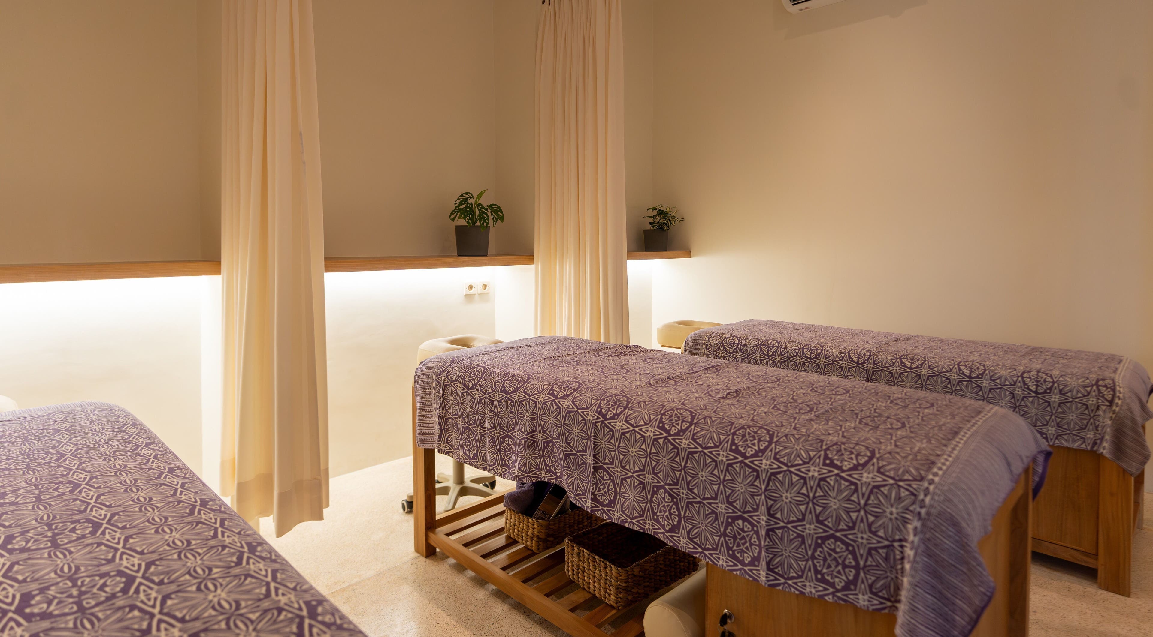 Relaxing massage room at Muscle Works, Bali, ID with two beds and calming decor.