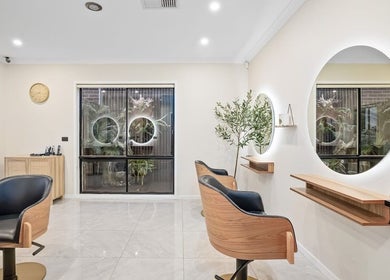 Modern salon interior at Yasu's Salon, Melbourne, Victoria, AU with sleek chairs and mirrors.