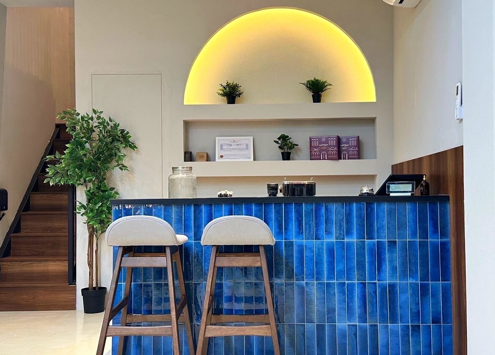 Stylish reception area at Milli Trims in Saar, Al-muḥāfaẓat Aš-šamālīyah, BH with blue tiled counter.
