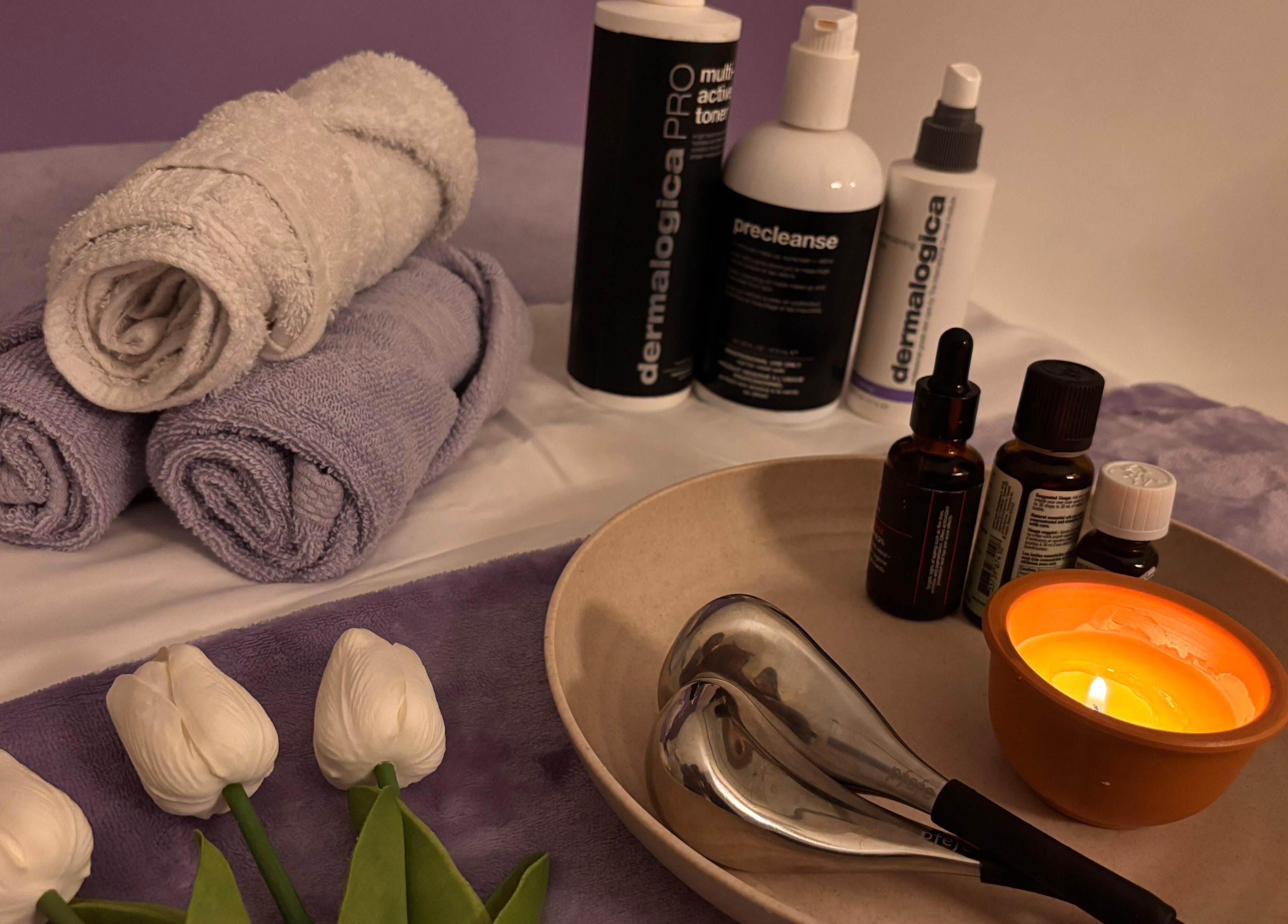Relaxing spa setup with towels and candles at QST Esthetics - Facials and Massage, Ottawa, Ontario, CA.
