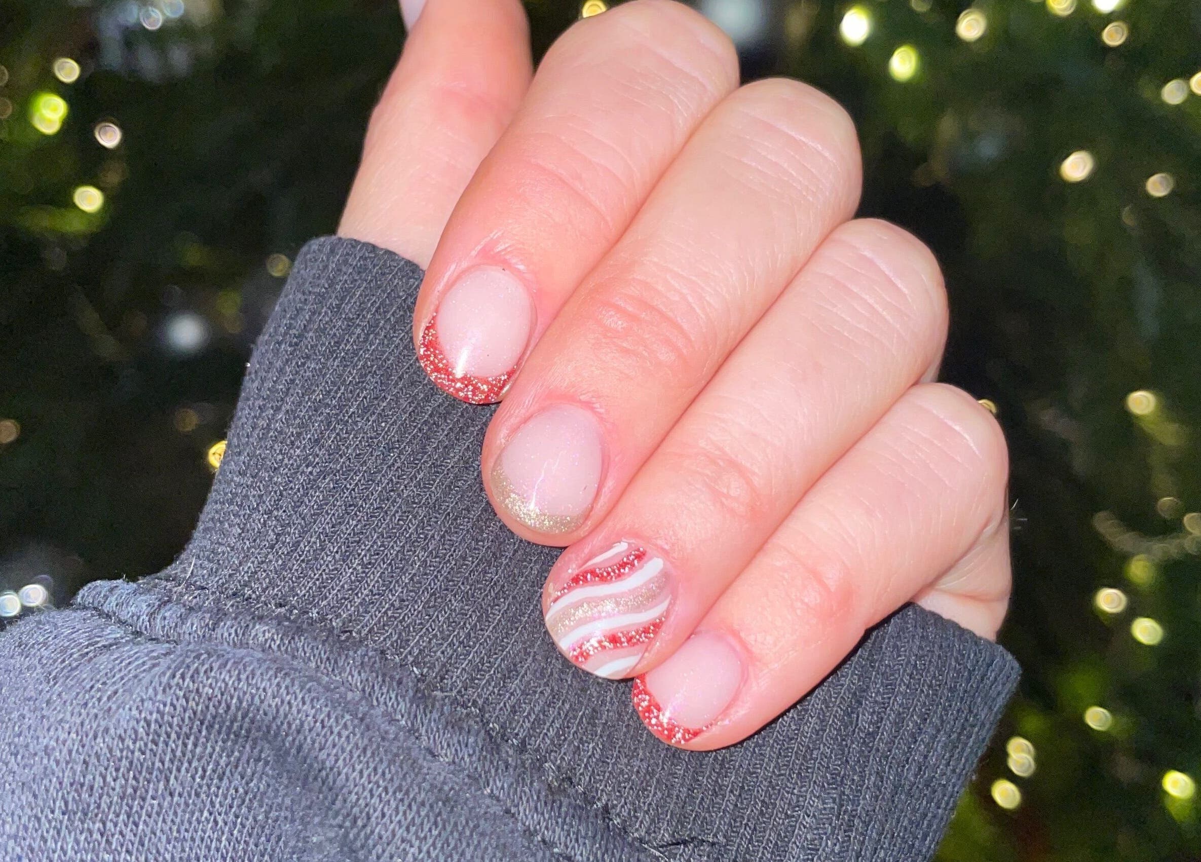 Festive nail art with red glitter tips at HLM Nails, Charfield, England, GB.