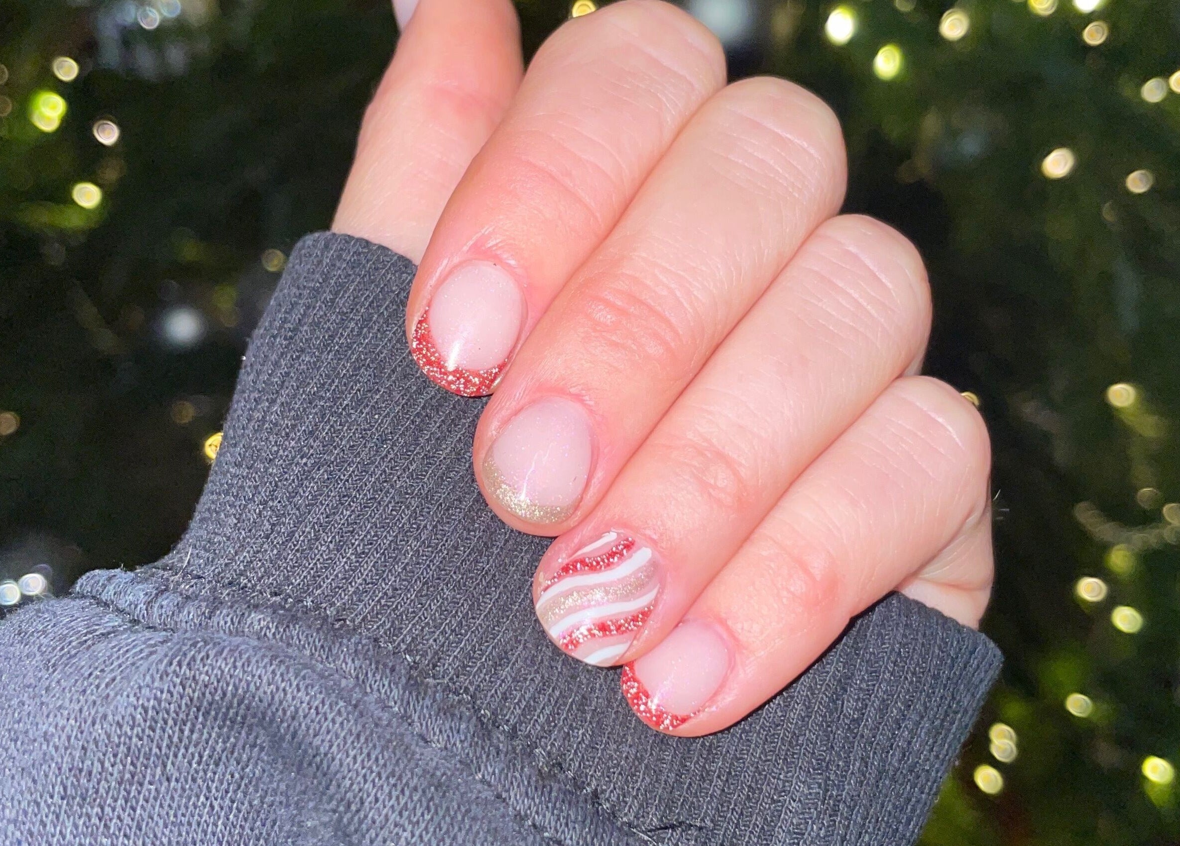 Festive nail art with red glitter tips at HLM Nails, Charfield, England, GB.