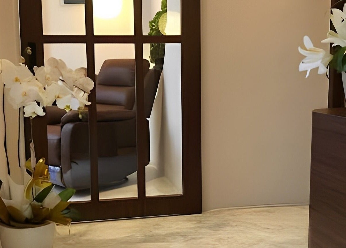 Inviting entryway of The Present Spa, Bali, Bali, ID, featuring potted orchids and modern decor.