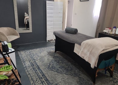 Serene treatment room at Habitual Beauty, Cape Town, Western Cape, ZA with massage bed and elegant decor.