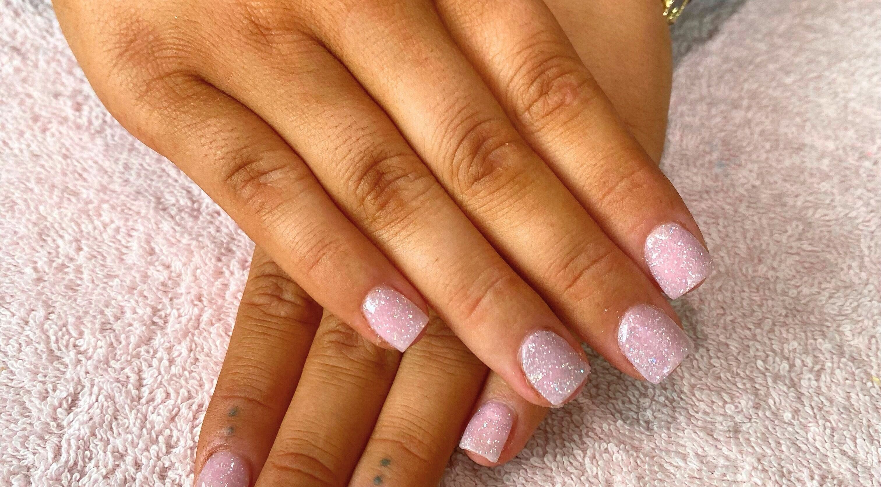 Sparkling pink nails on display at Beauty_by_marni, Fen Street, England, GB.
