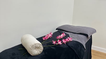 Tranquil massage table adorned with pink flowers at SKR Beauty Bar, Broadbridge Heath, England, GB.