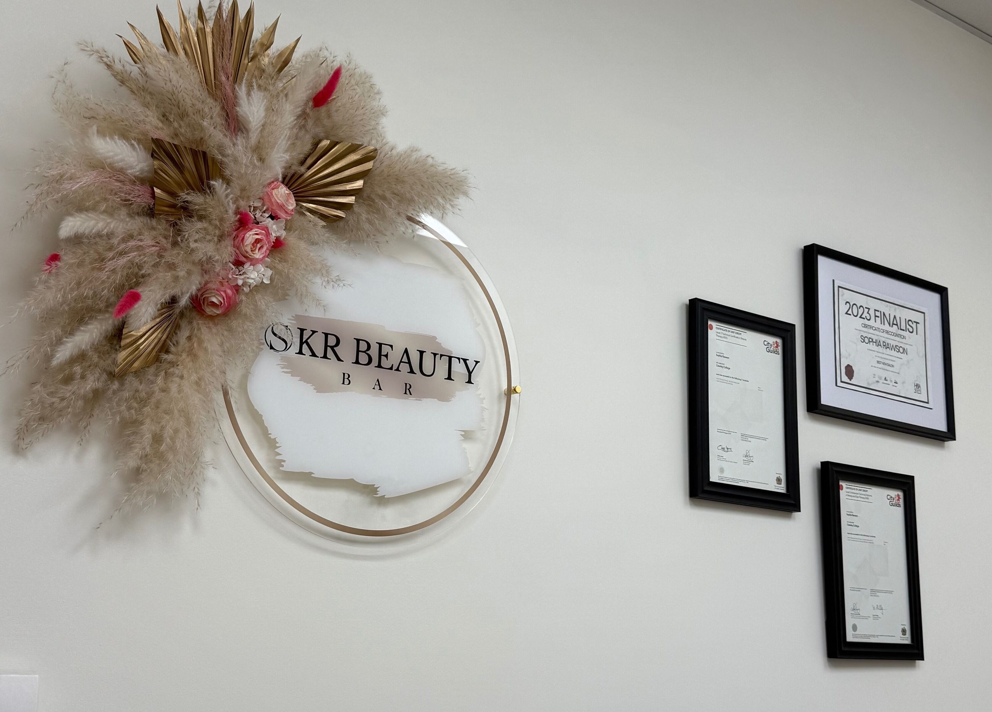 Elegant wall decor with floral accents at SKR Beauty Bar, Broadbridge Heath, England, GB. Award certificates displayed.