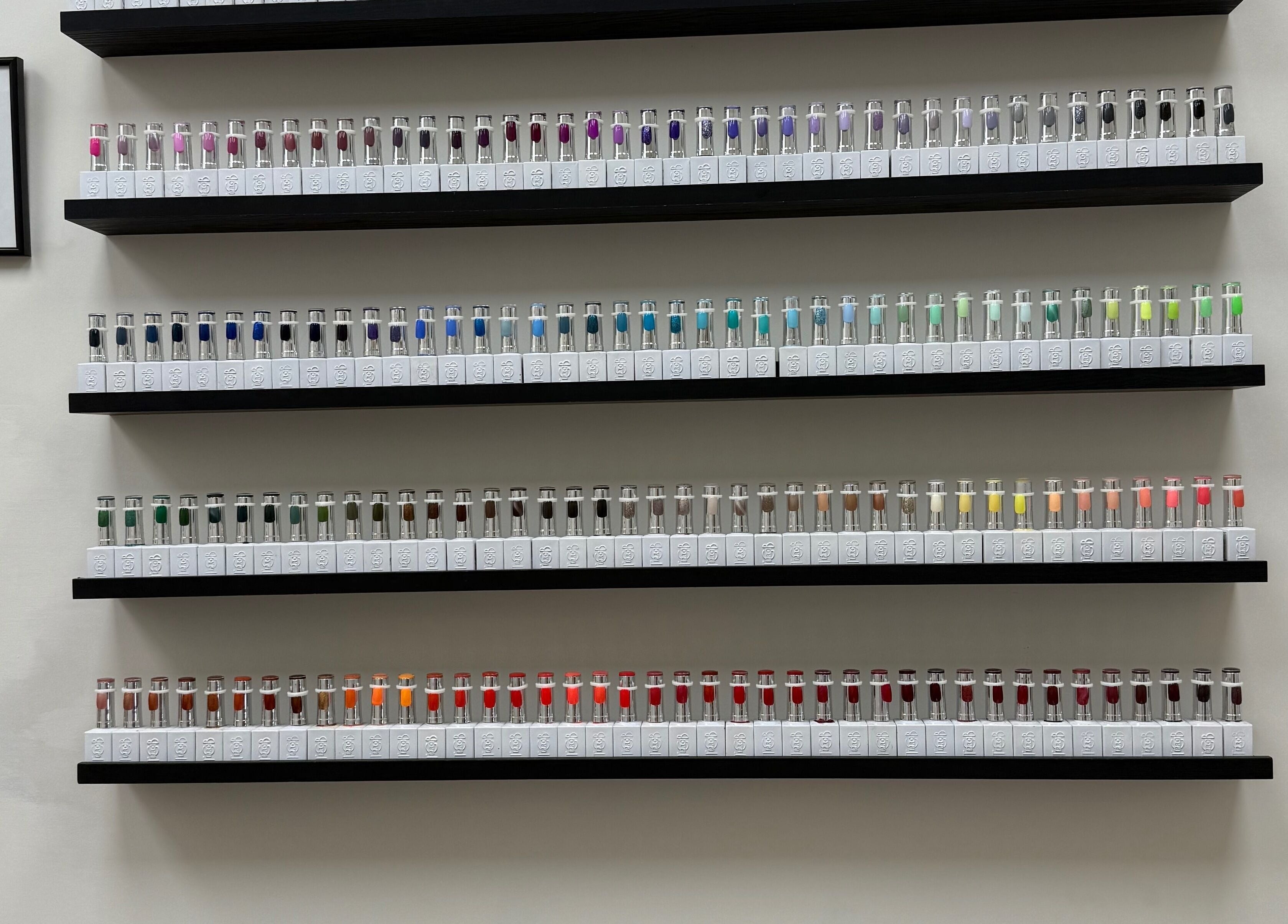 Vibrant nail polish collection at SKR Beauty Bar, Broadbridge Heath, England, GB. Shelves filled with colorful bottles.