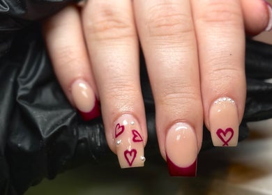 Nail art with heart designs and burgundy tips at Lvy Luxe Nails, Swindon, England, GB.