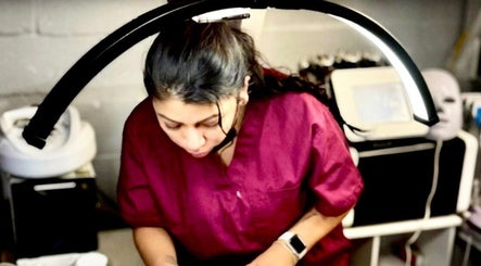 Aesthetician at Diamond Glow in Malden, Massachusetts, US, focusing under a treatment light.