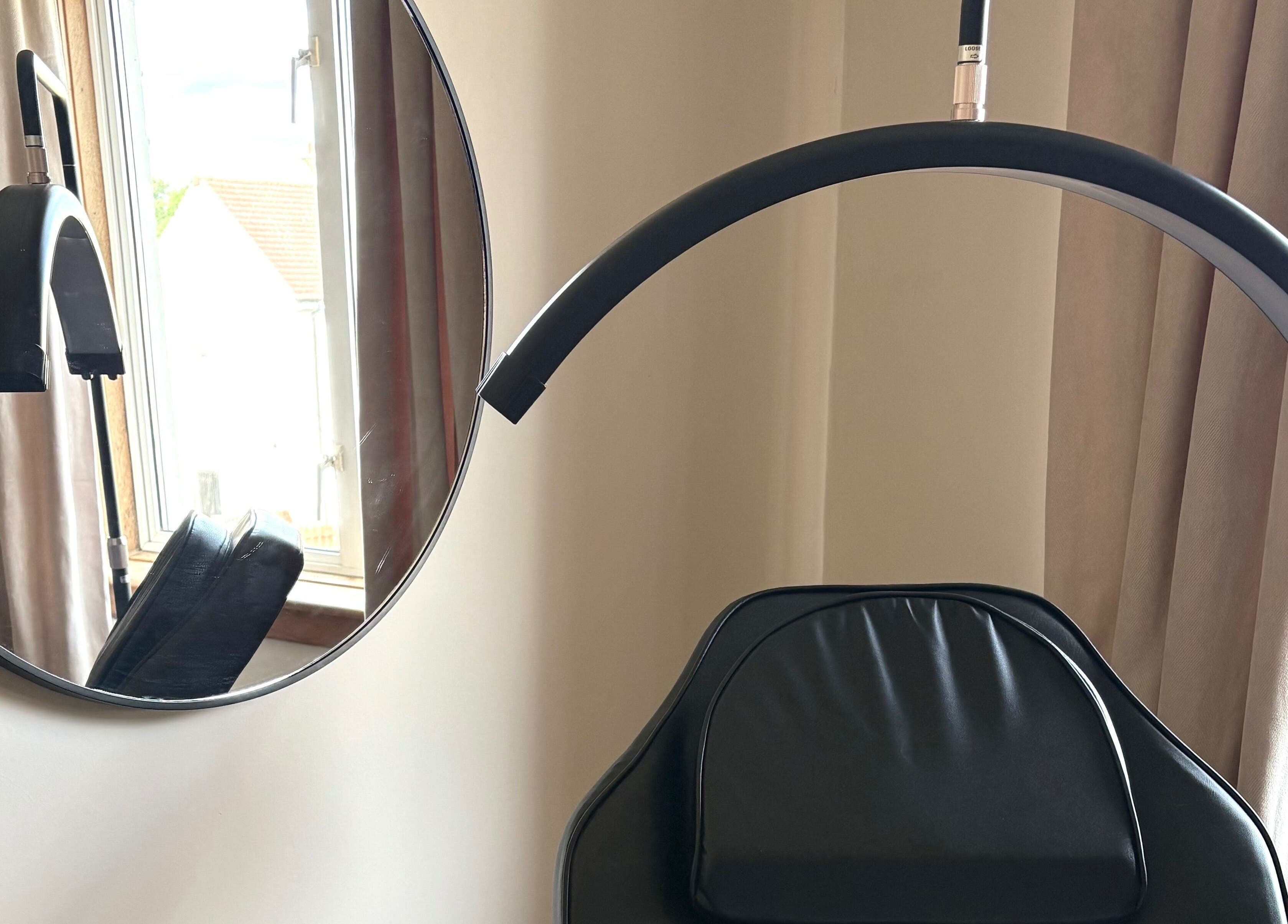 Modern salon chair and round mirror in Cat’s Eyes, Kilbarchan, Scotland, GB.