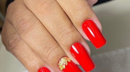 Unhas vermelhas decoradas com folha dourada no salão Anne Silva, Paraná, Paraná, BR.