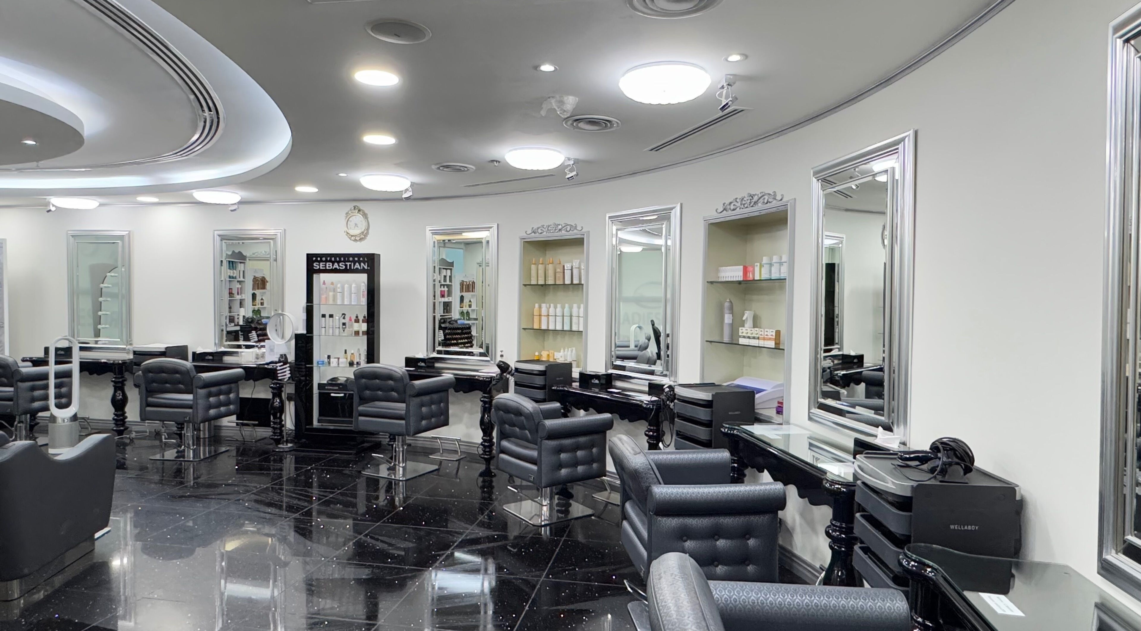 Chic interior of L'atelier Hair & Beauty Salon in Dubai, Dubai, AE with styling chairs and mirrors.