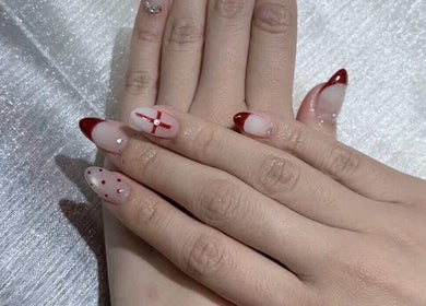 Stylish nail art at Qlean Nails, Singapore, SG featuring red accents on a shimmering background.