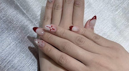 Stylish nail art at Qlean Nails, Singapore, SG featuring red accents on a shimmering background.