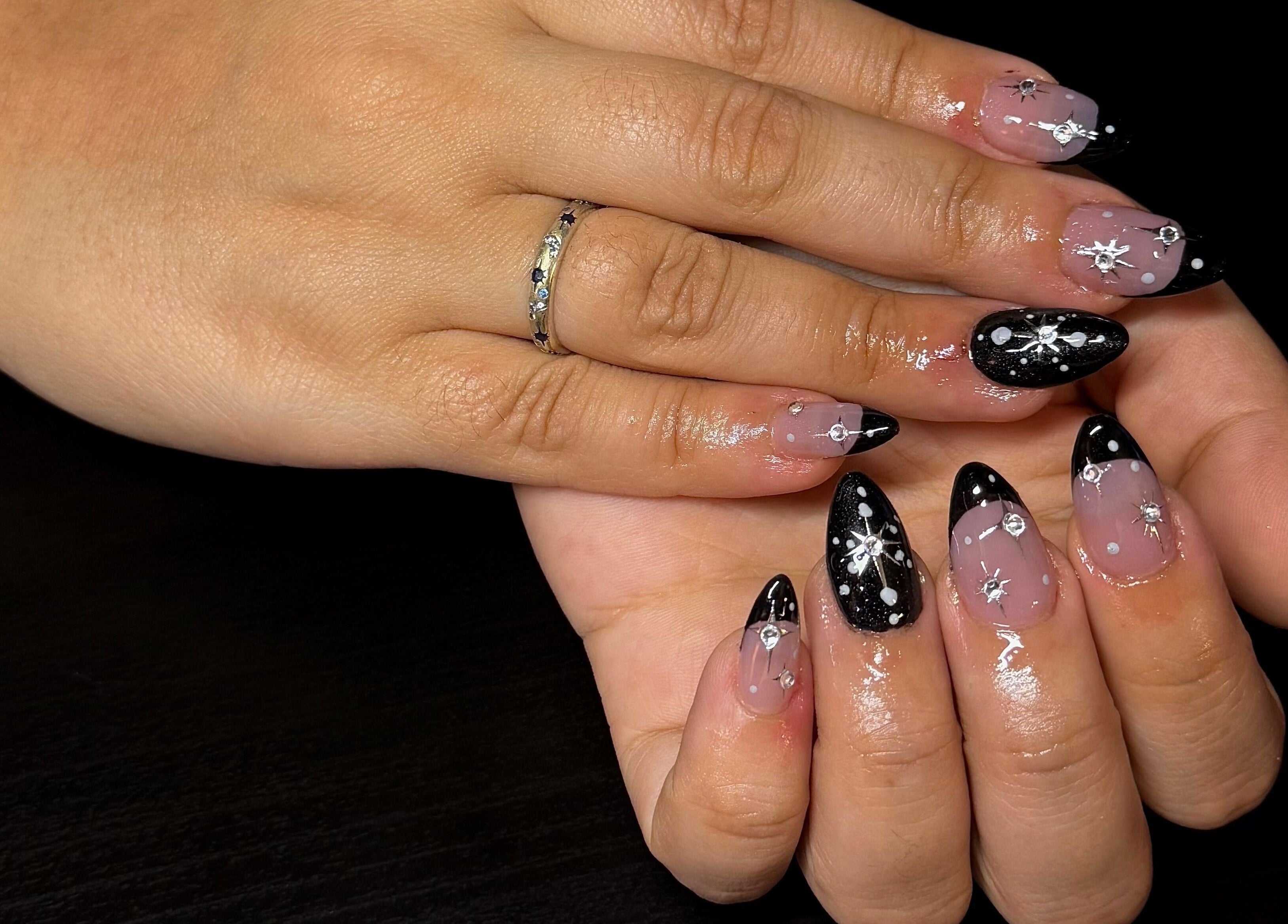 Dazzling star-themed manicure at Opal & Claws, Hurst, Texas, US. Elegant black and silver nail art.