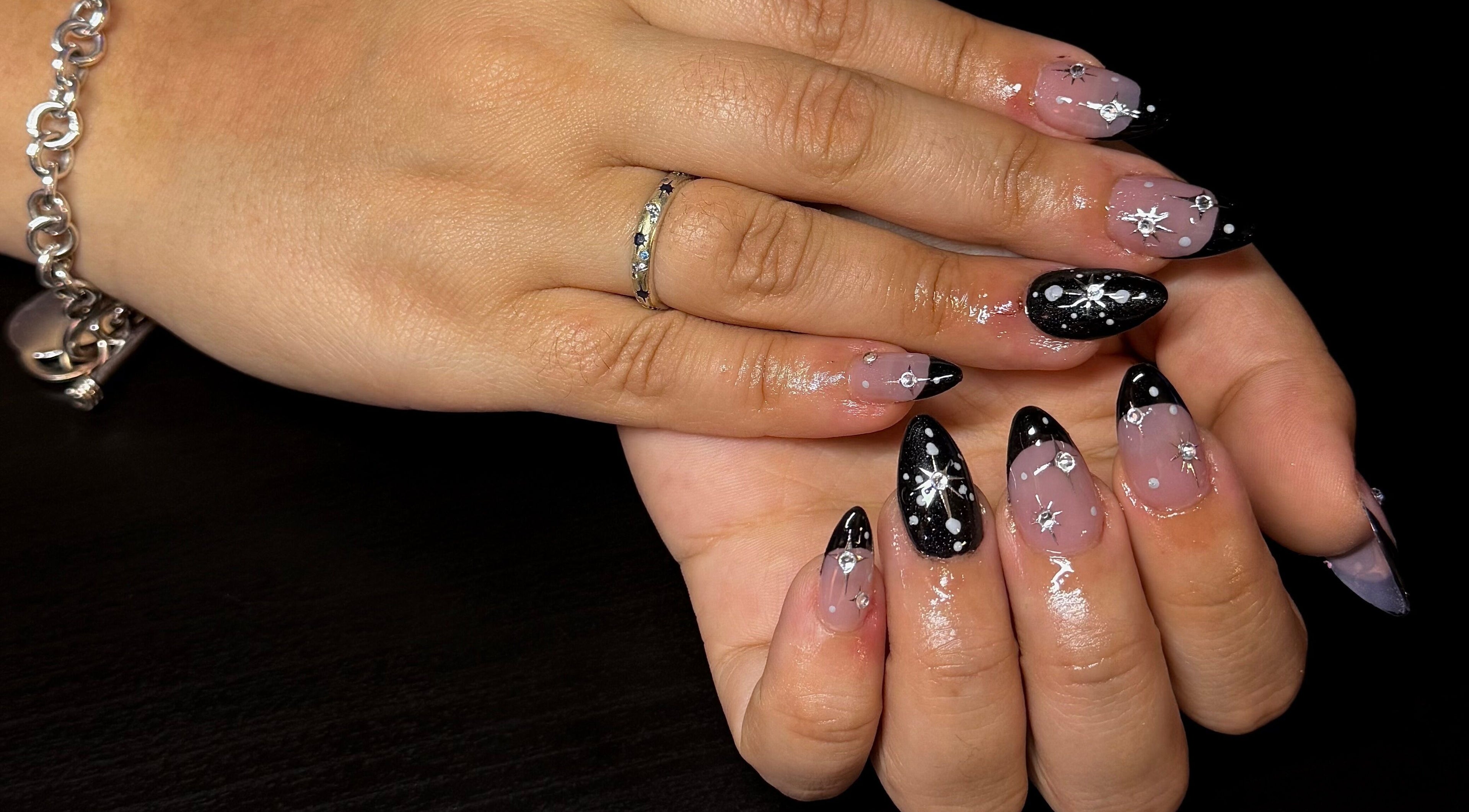 Dazzling star-themed manicure at Opal & Claws, Hurst, Texas, US. Elegant black and silver nail art.