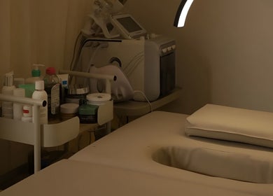 Relaxing treatment room at 8 Infiito Salon, Jeddah, Makkah Province, SA with skincare products and massage bed.