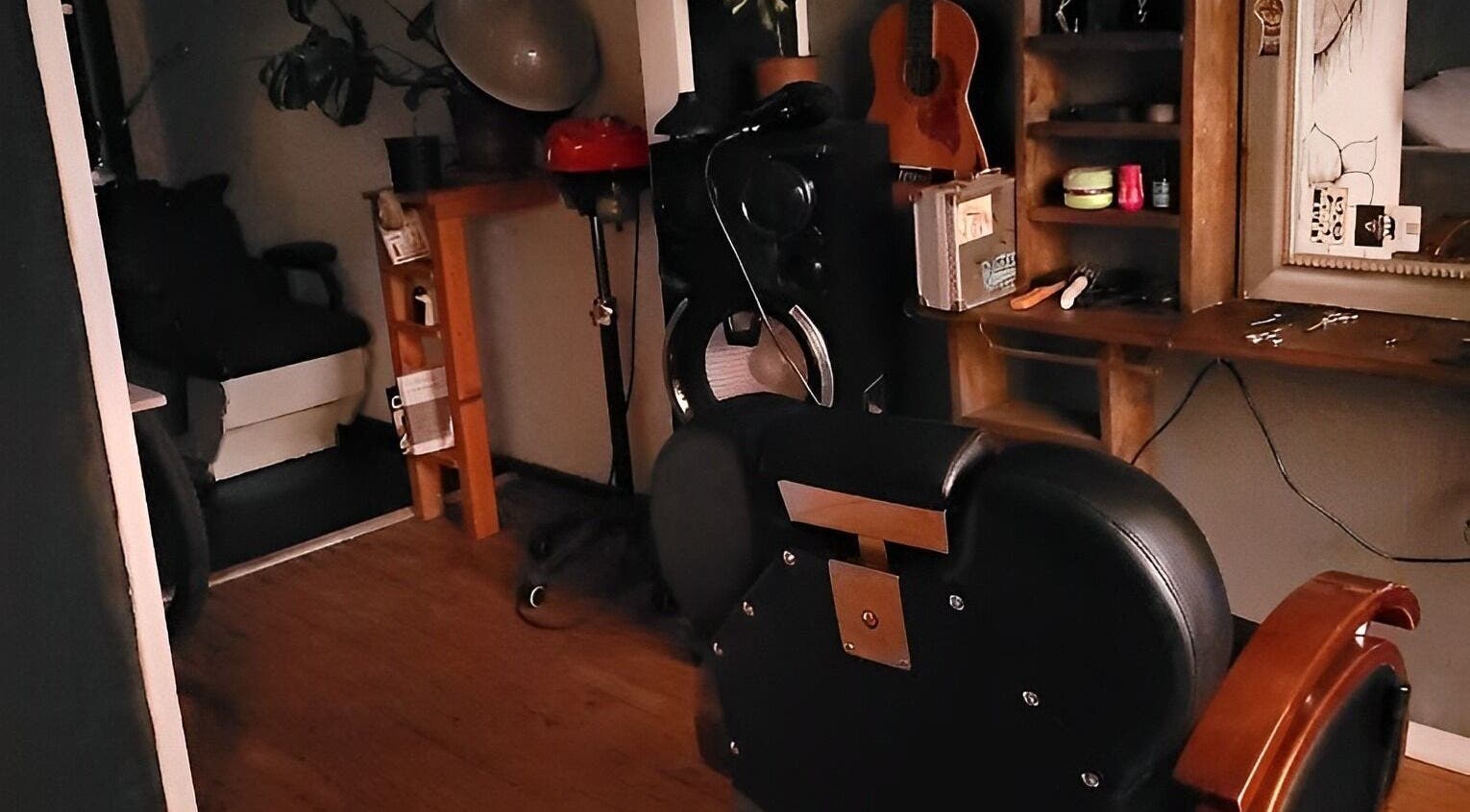 Acogedor interior de Barberia Alquimista en San Pedro De La Paz, Bío Bío, CL, mostrando asiento y decoraciones.