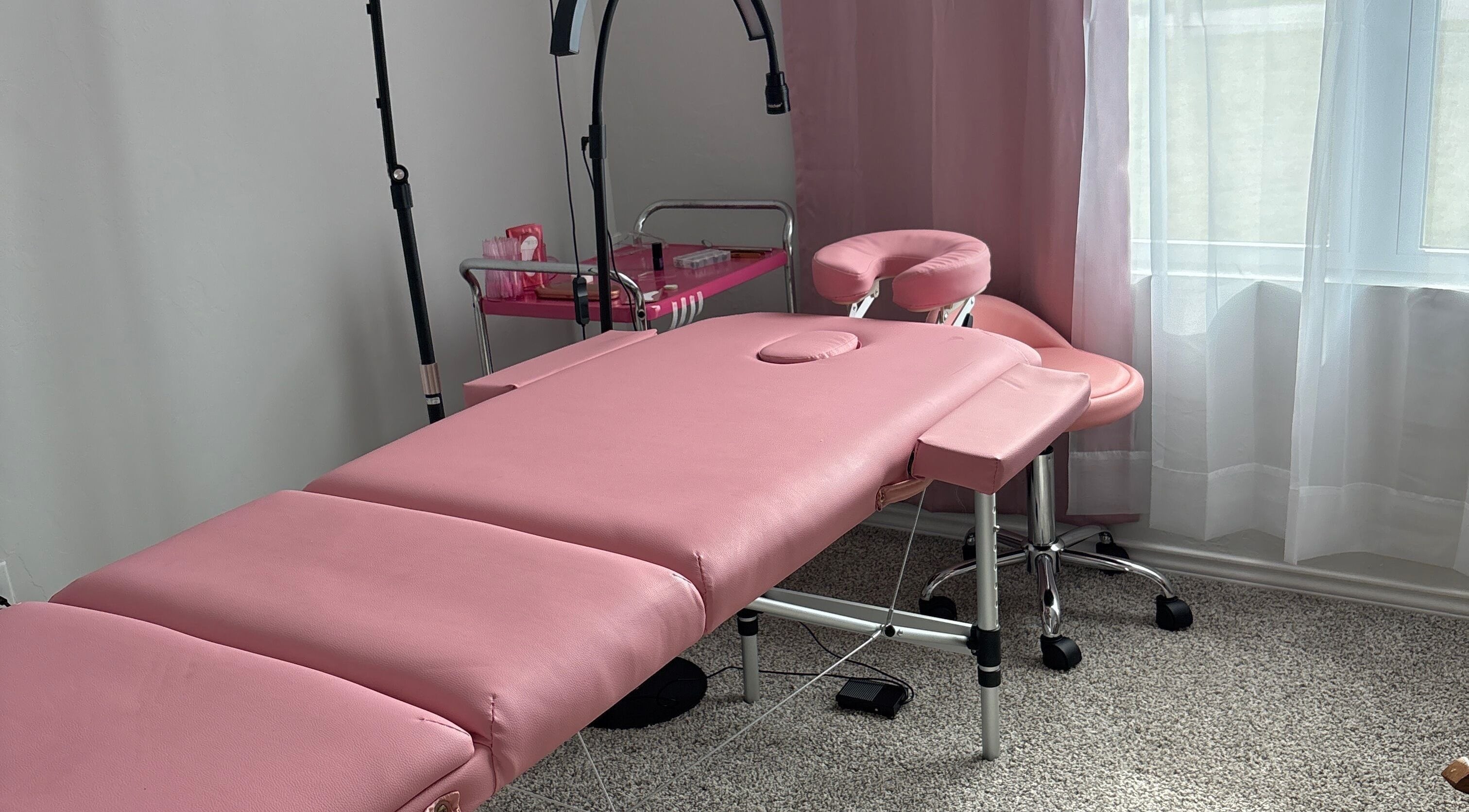 Relaxing pink massage setup at Britlyn Begley in Shawnee, Oklahoma, US with plush table and soft lighting.