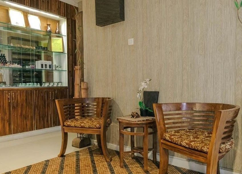 Elegant waiting area at Spa Central Batam, Kepulauan Riau, ID, featuring wooden chairs and a bamboo decor.