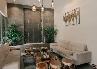 Elegant lounge area at Spa Central Nagoya, Kepulauan Riau, featuring modern decor and lush greenery.