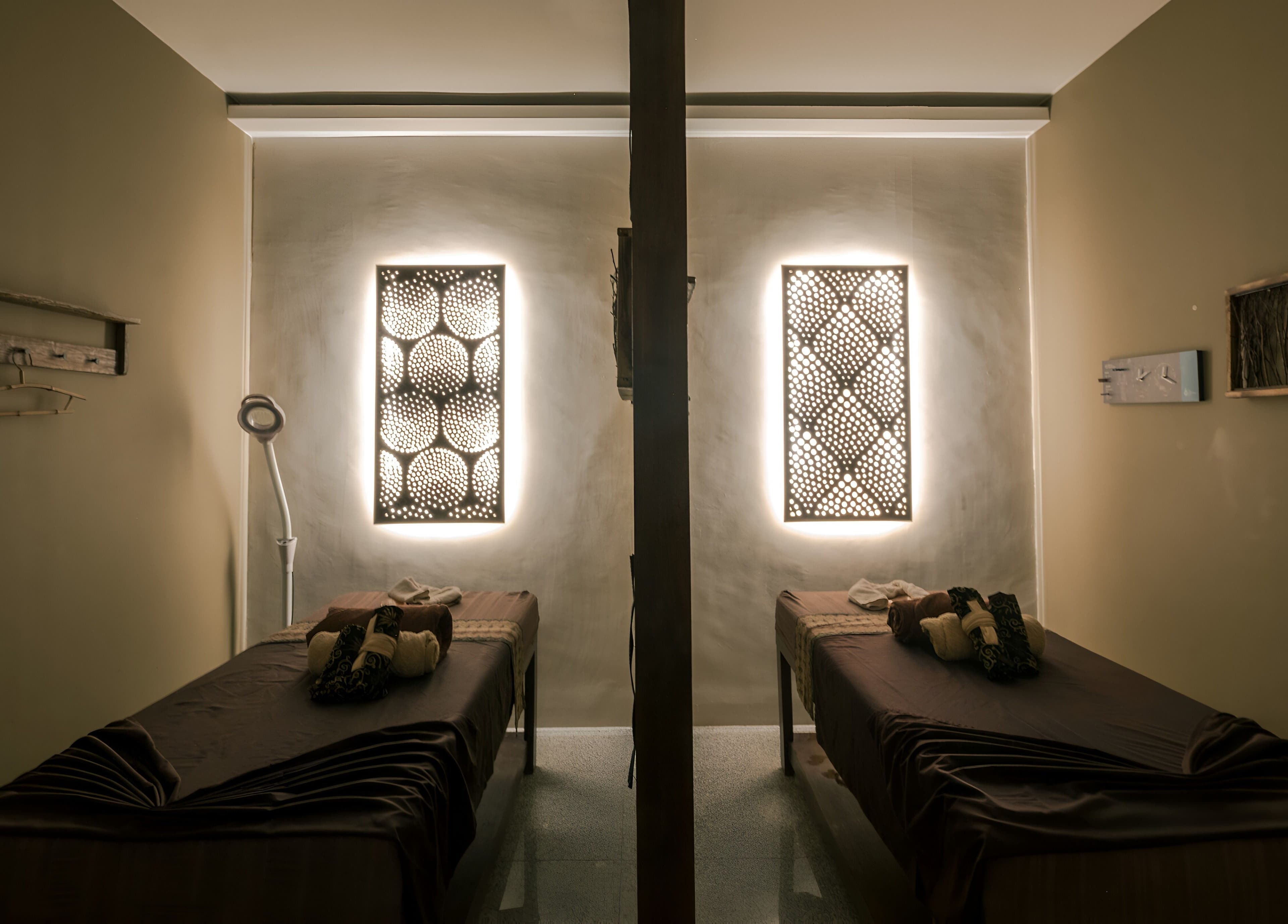 Relaxing treatment room at Spa Central Nagoya, Kepulauan Riau, ID with illuminated decor and twin massage beds.