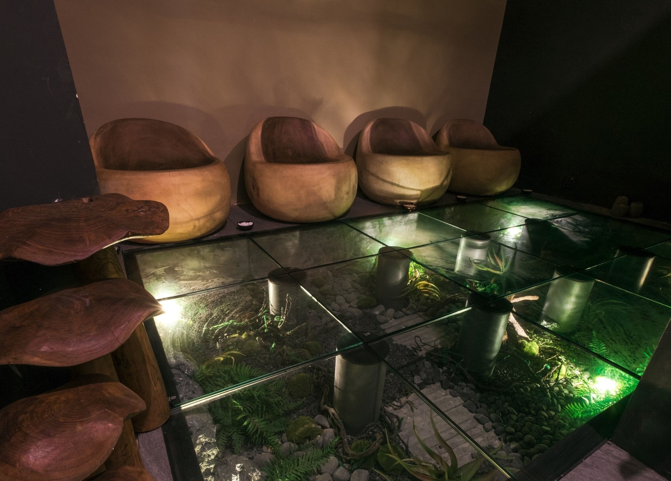 Relaxing seating area at Spa Central Nagoya, Kepulauan Riau with glass floor and ambient lighting.