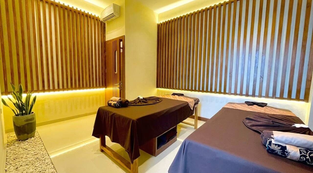 Spa Central Baloi massage room in Kepulauan Riau features tranquil ambiance with warm lighting and wooden accents.