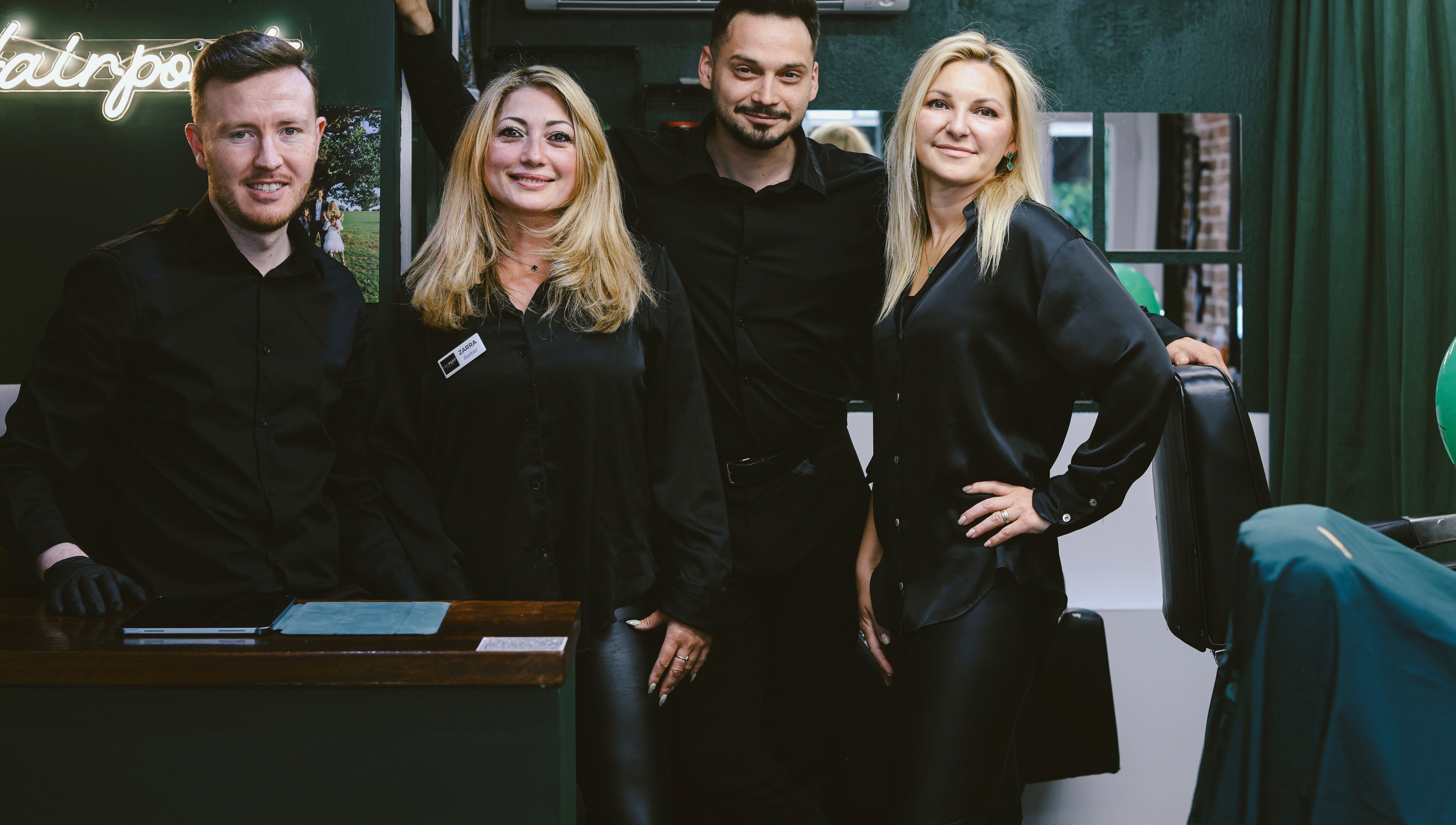 Team at Hairport, Bushey, England, GB smiles in a stylish salon setting.