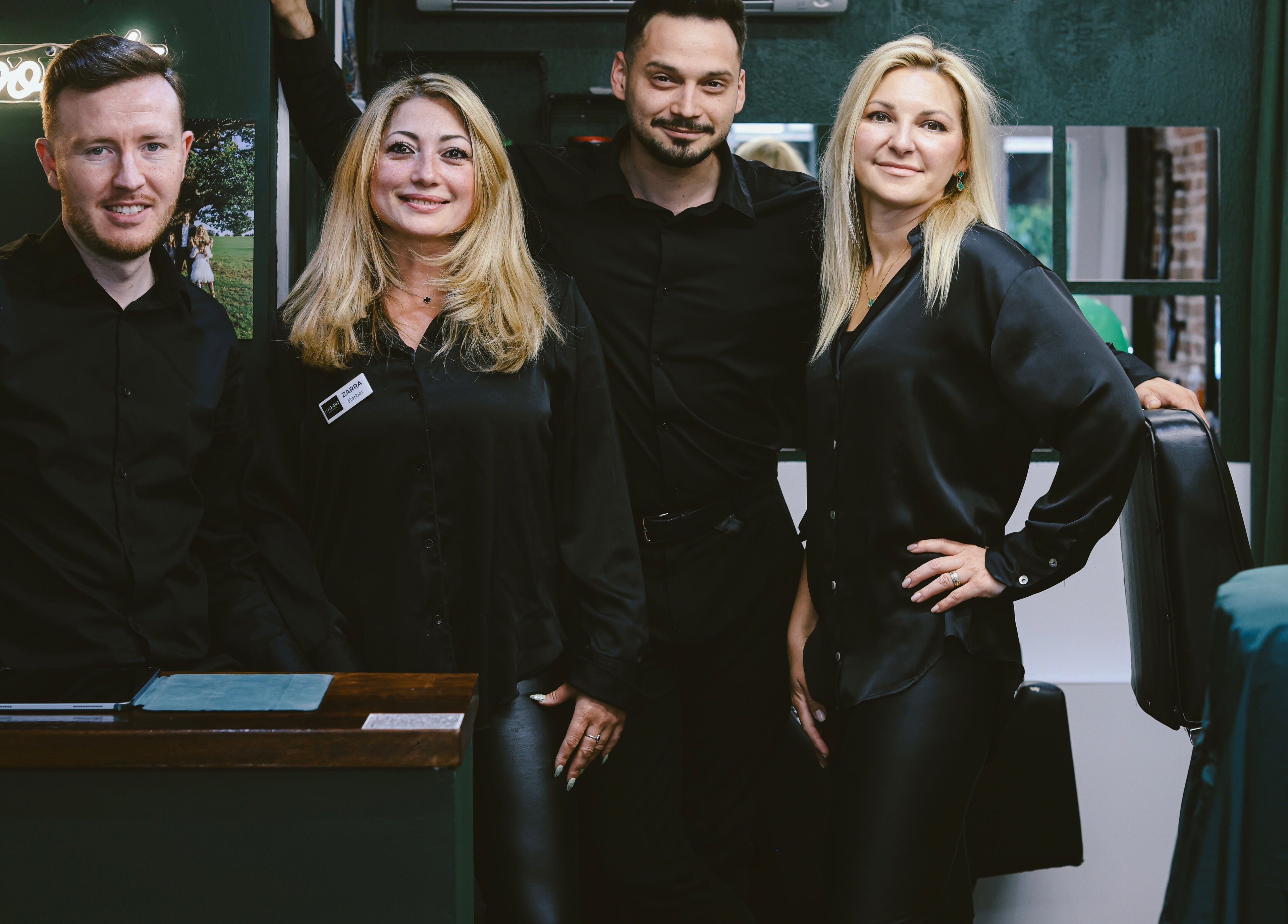 Team at Hairport, Bushey, England, GB smiles in a stylish salon setting.