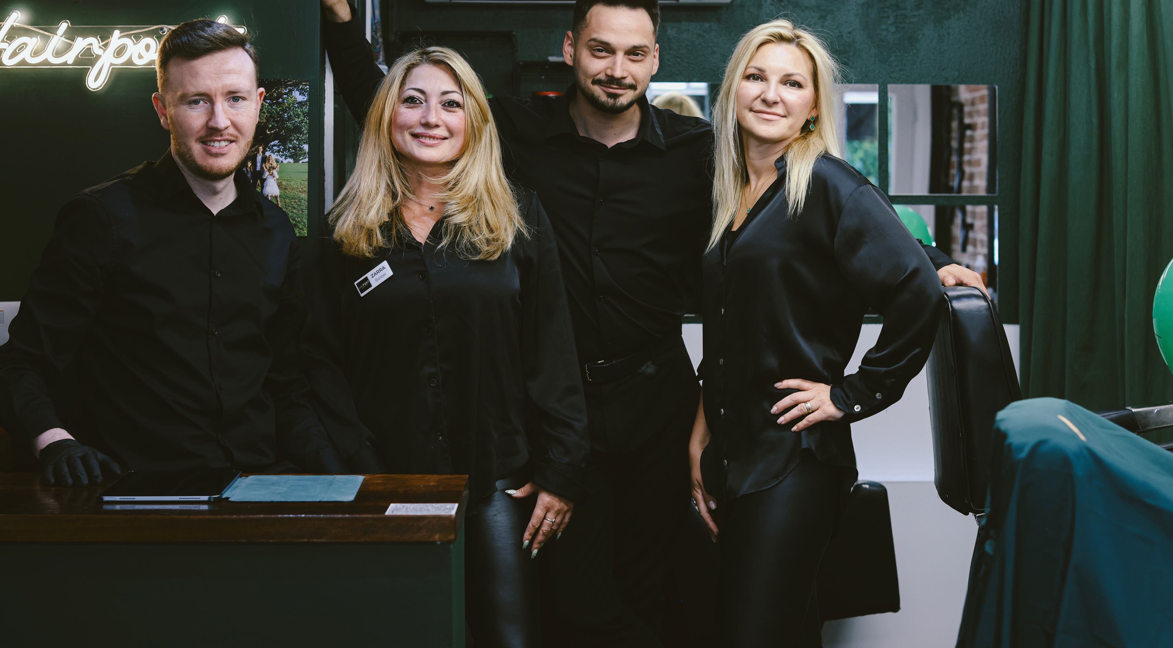 Team at Hairport, Bushey, England, GB smiles in a stylish salon setting.
