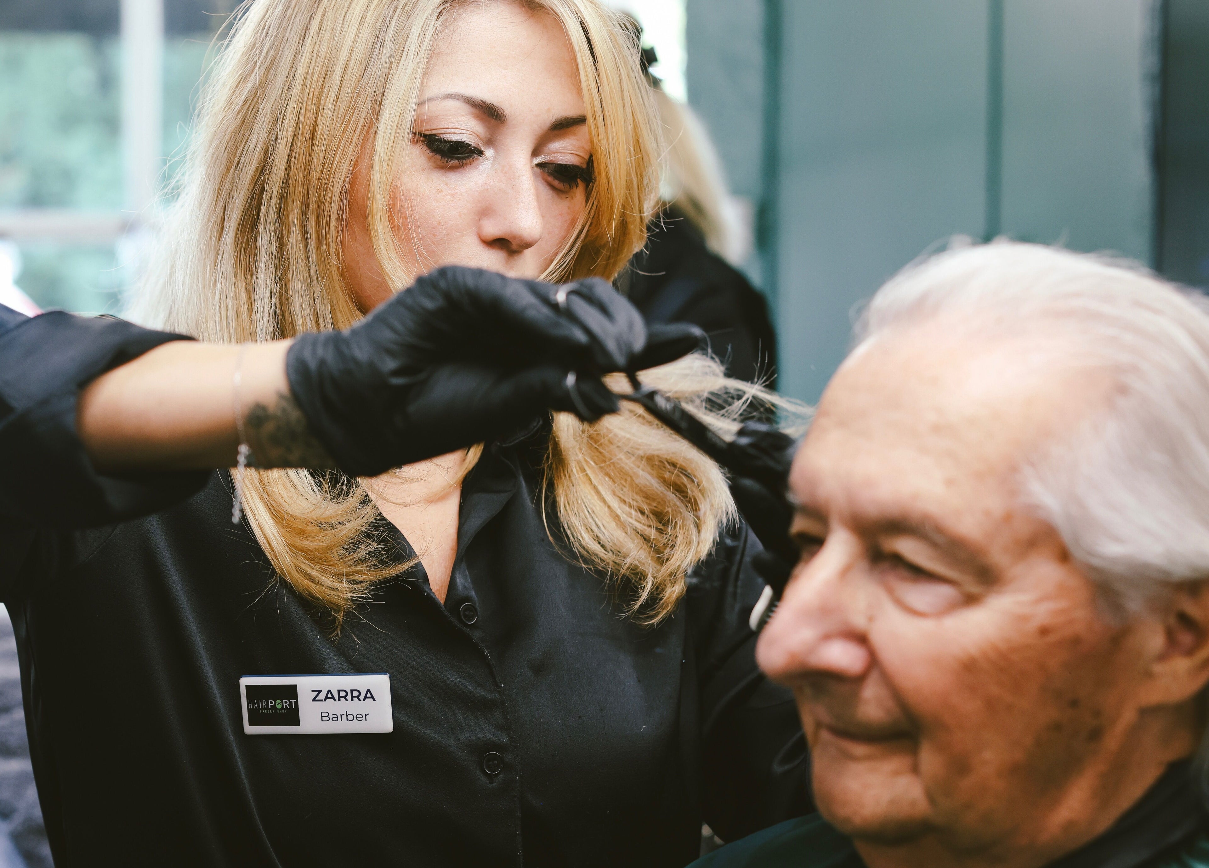 Professional stylist cutting hair at Hairport in Bushey, England, GB providing a chic and modern experience.