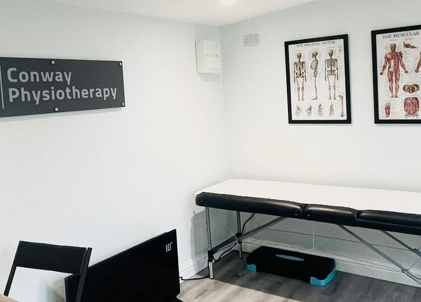 Conway Physiotherapy therapy room with treatment bed and anatomical charts in Ratby, England, GB.