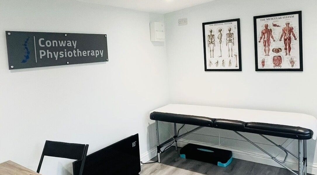 Conway Physiotherapy therapy room with treatment bed and anatomical charts in Ratby, England, GB.