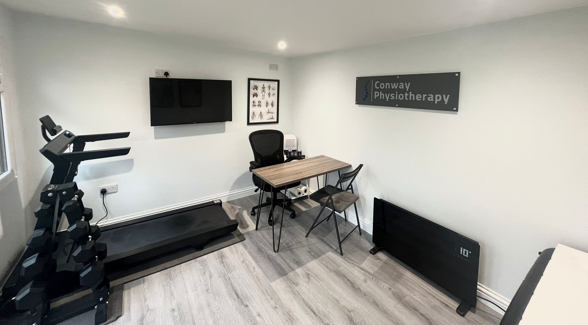 Conway Physiotherapy in Ratby, England, GB: modern therapy room with treadmill, desk, and health posters.