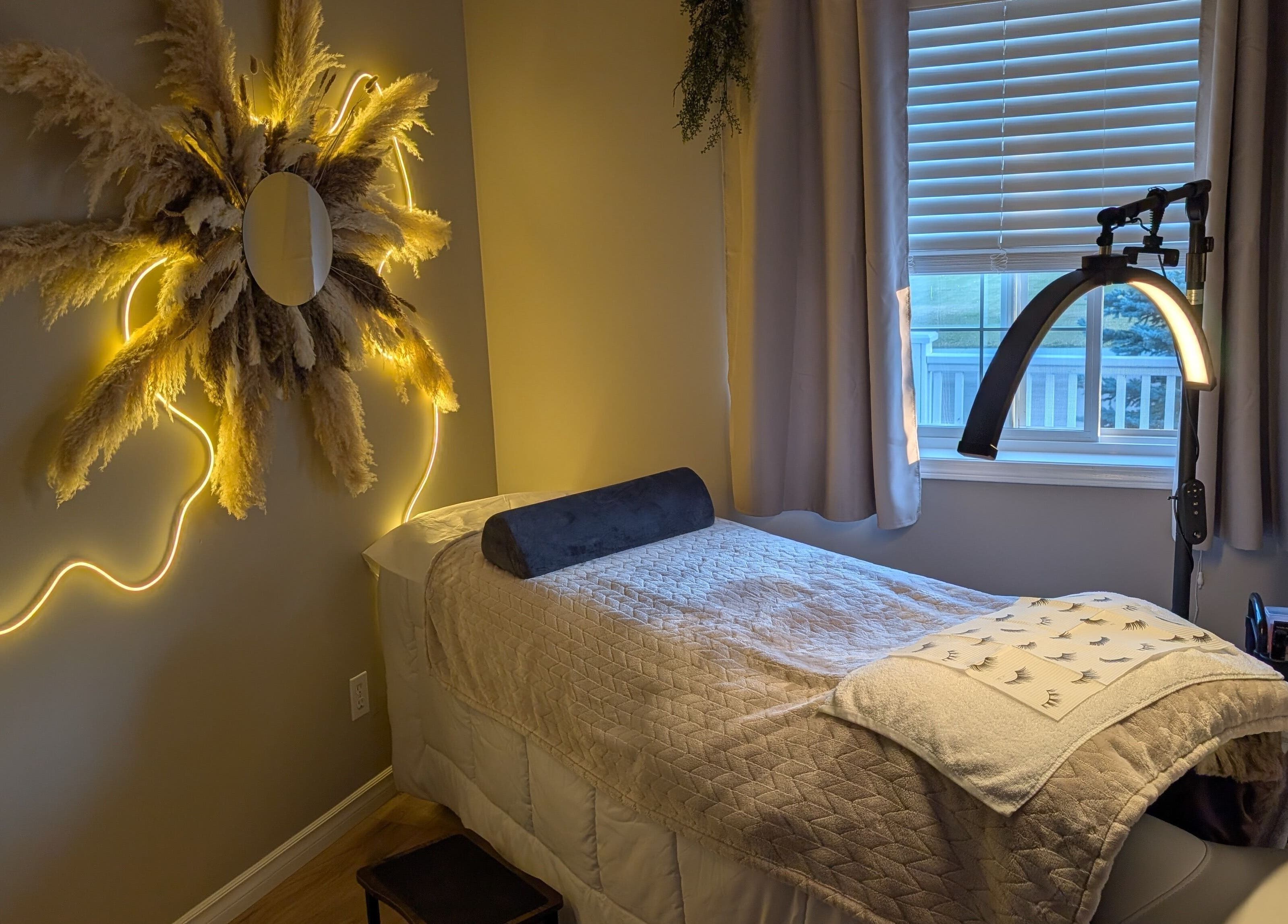 Relaxing spa room at Country Lashes in Warburg, Alberta, CA with cozy bed and elegant light decor.