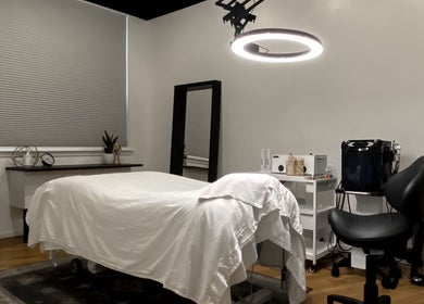 Luxurious treatment room at Esthetic Society, Bellevue, Washington, US with a cozy bed and elegant decor.