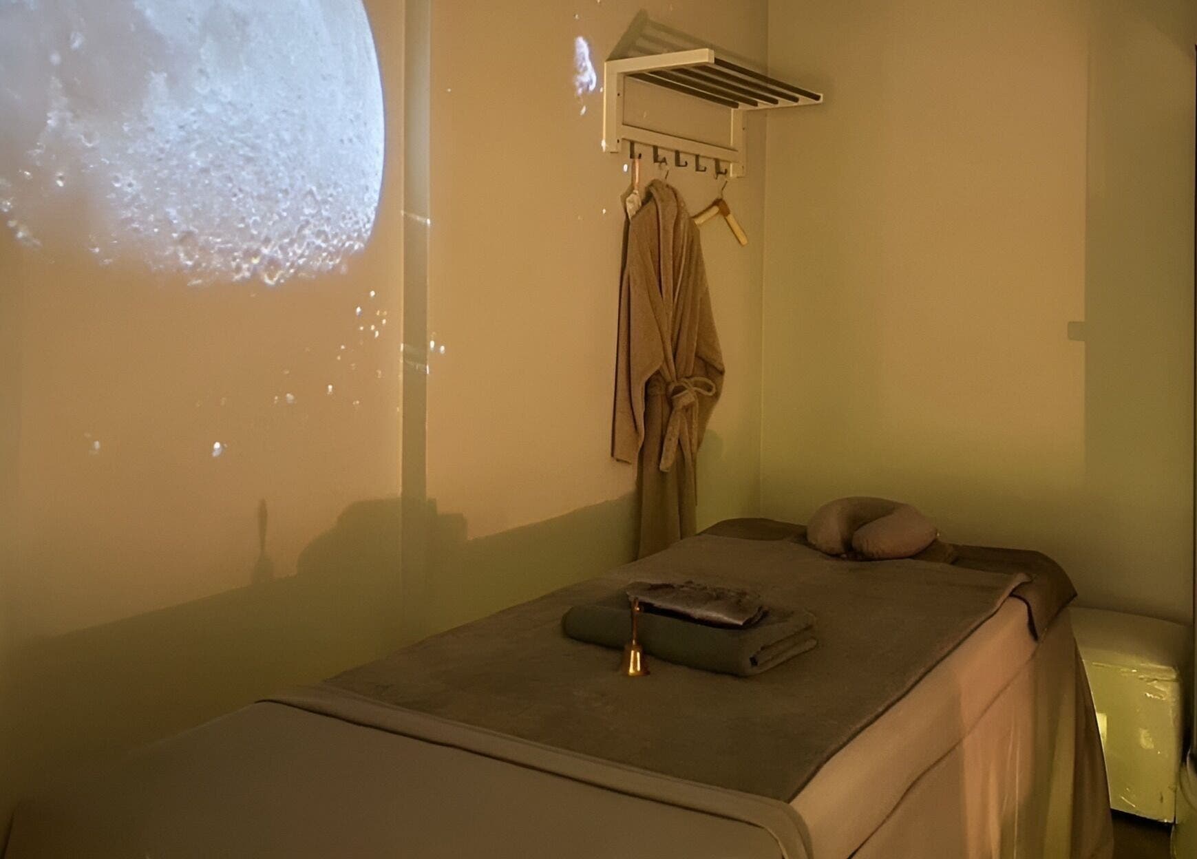 Serene massage room at XINGSPA, กรุงเทพมหานคร with moonlit ambiance and cozy robe.