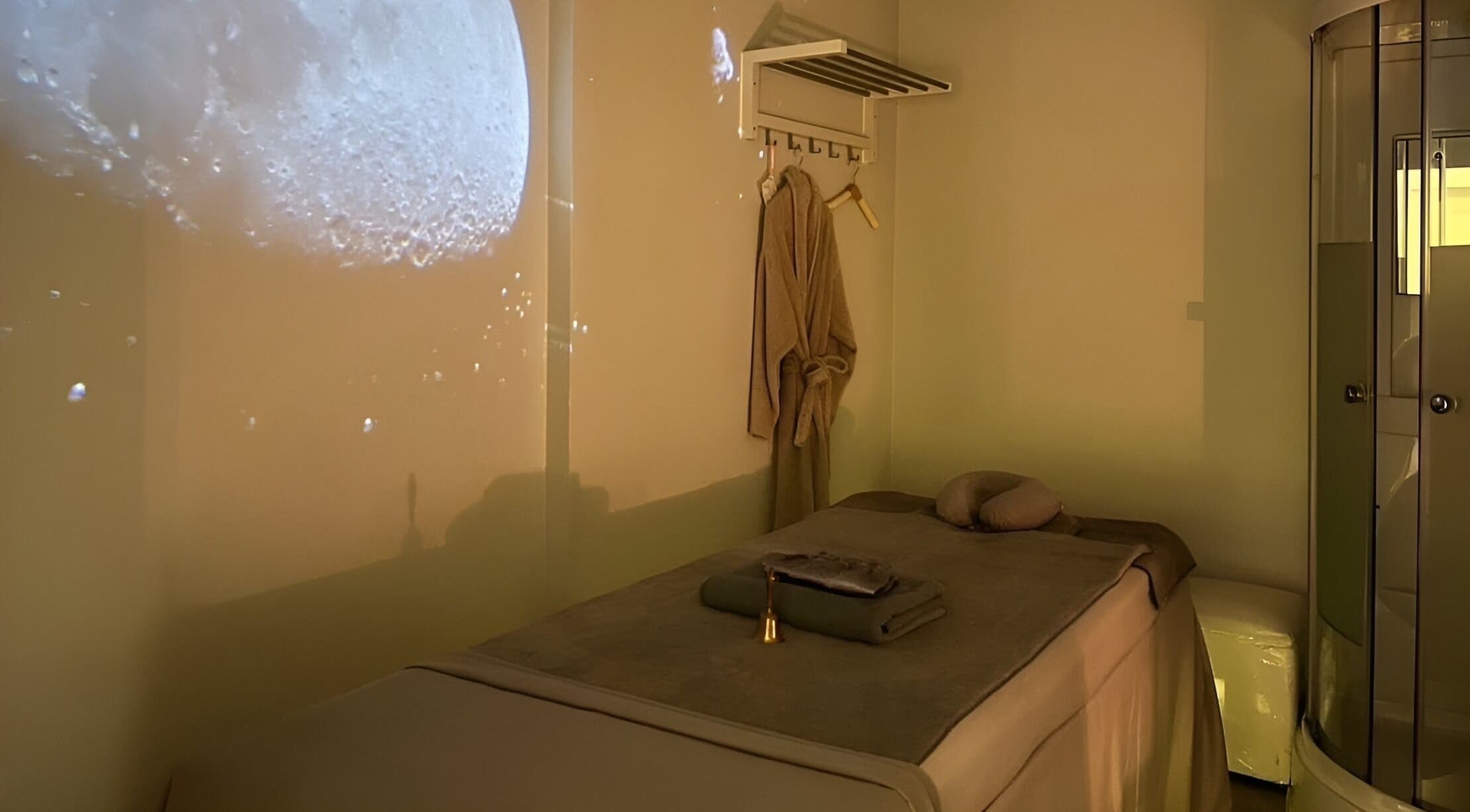Serene massage room at XINGSPA, กรุงเทพมหานคร with moonlit ambiance and cozy robe.