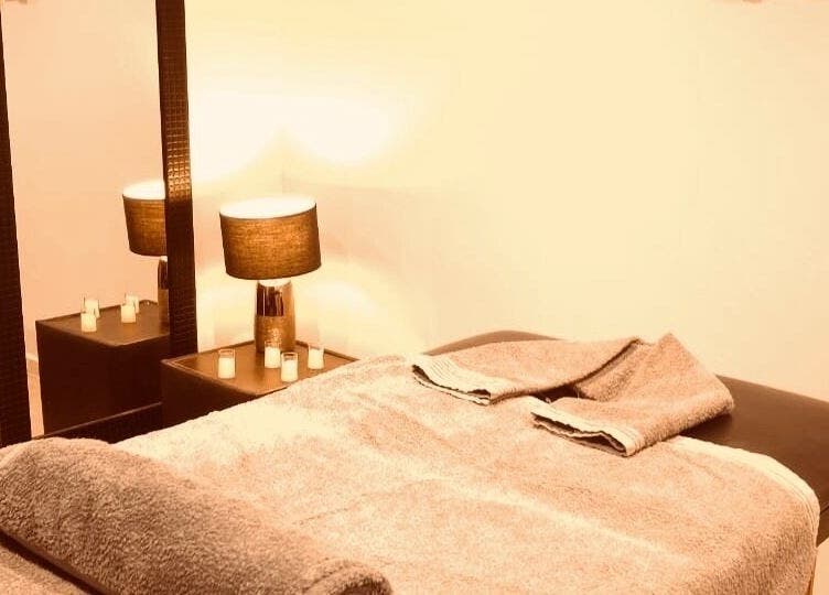 Relaxing massage room at Statera Massage Studio, Cape Town, Western Cape, ZA, featuring cozy lighting and soft towels.