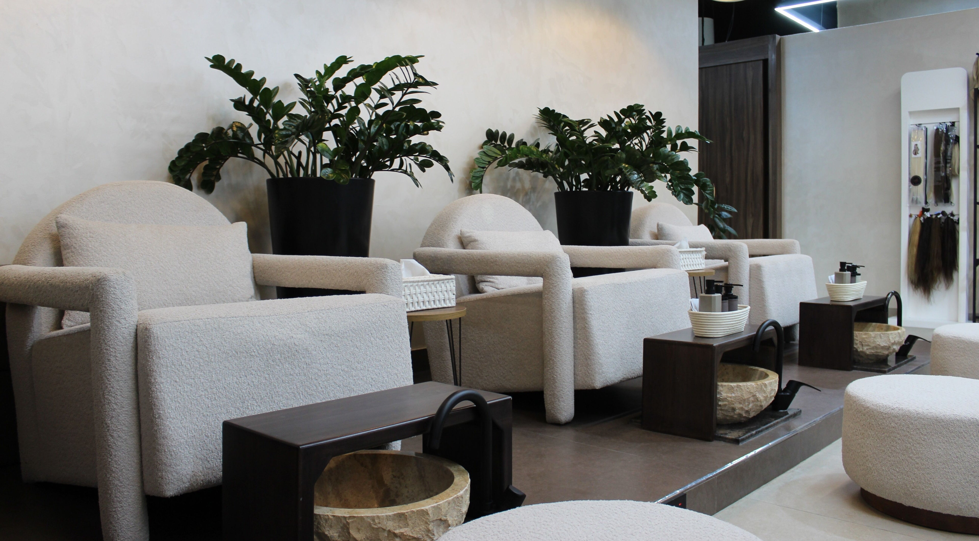 Relaxing seating area at Copper Beauty Salon, Dubai, Dubai, AE, featuring plush chairs and lush plants.